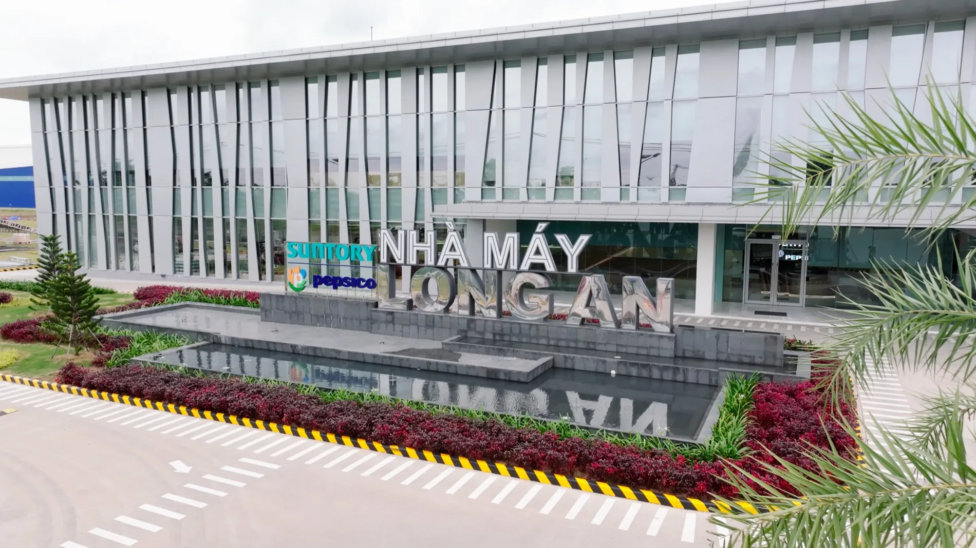 Cổng chính Nhà máy Suntory PepsiCo Long An với hồ cảnh quan